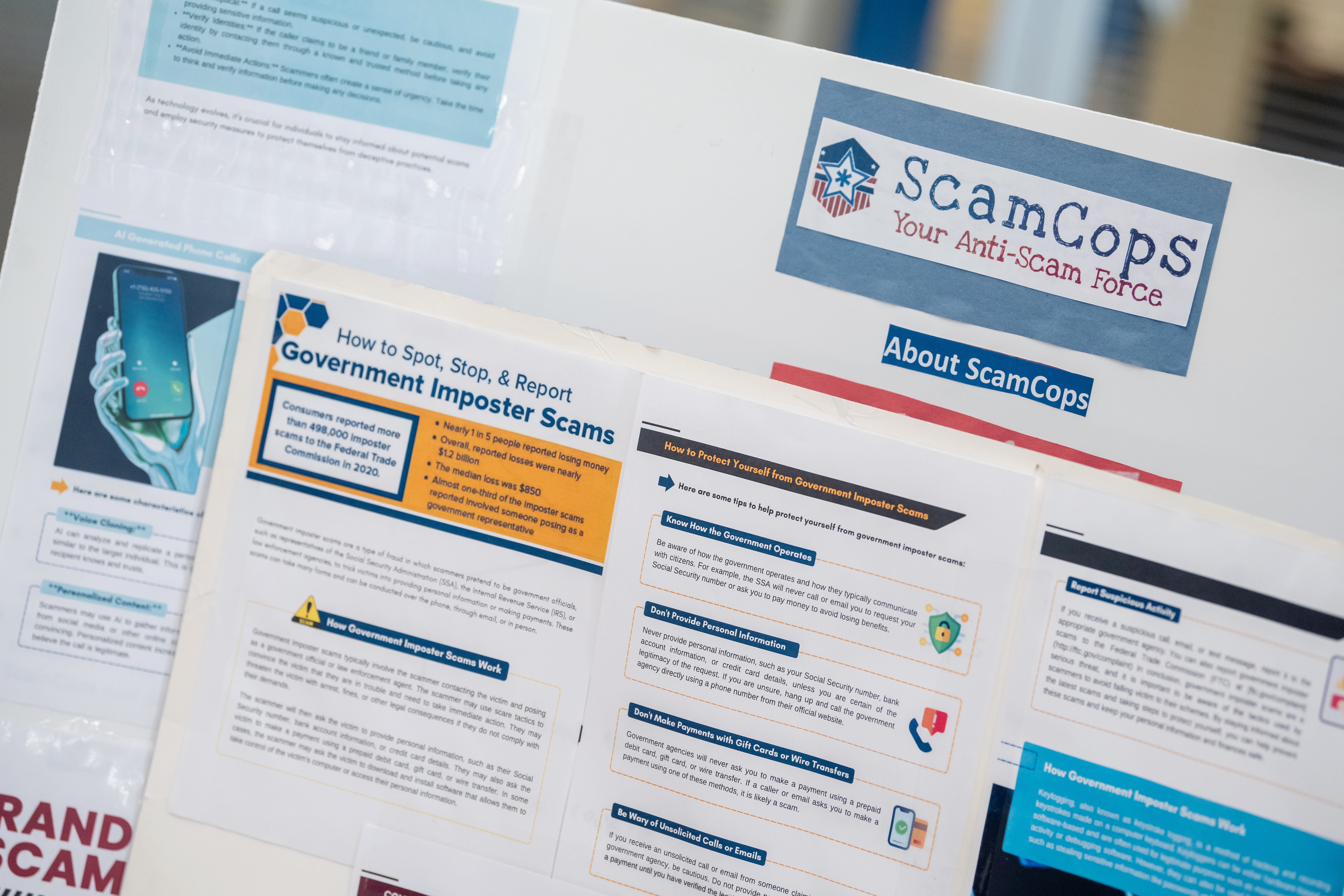 A poster board details the website ScamCops and lists many common scams.